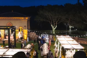 Fairmont Grand Del Mar wedding lighting with tree uplighting, string lights, and tented dining areas at nighttime reception