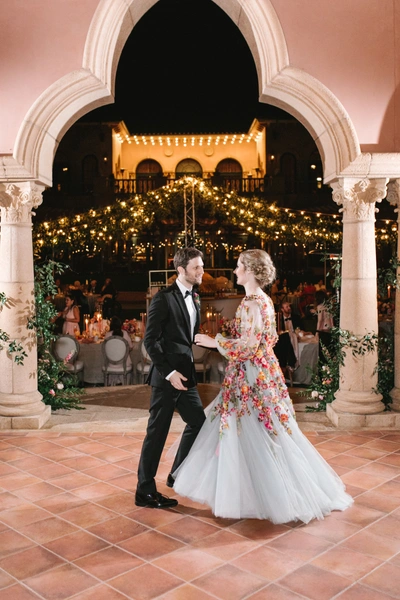 Fairmont Grand Del Mar wedding lighting with warm string lights creating romantic reception ambiance under archway