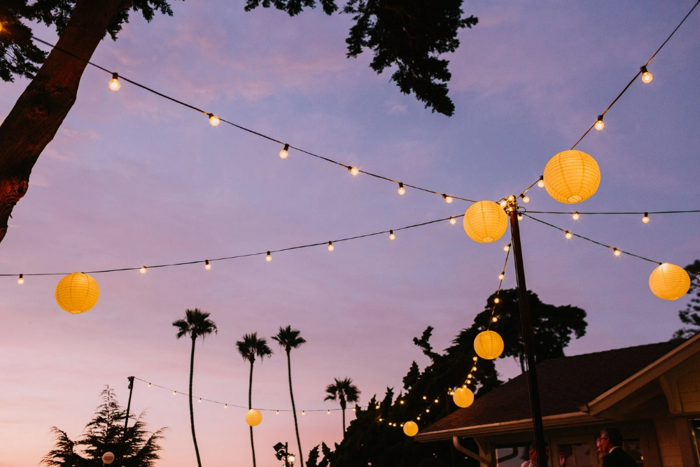 Martin Johnson House wedding lighting with market lights and hanging lanterns glowing at sunset in La Jolla San Diego