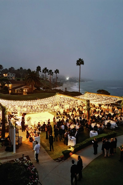 Montage Laguna Beach wedding lighting with large twinkle canopy covering outdoor reception overlooking ocean at night