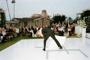 Montage Laguna Beach wedding lighting with string light canopy over dance floor and outdoor reception crowd at sunset