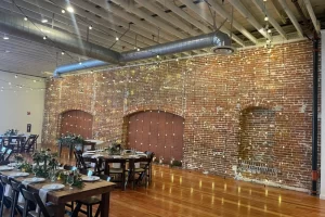Sinclair on G Street wedding lighting with string lights and uplighting highlighting exposed brick walls in San Diego venue