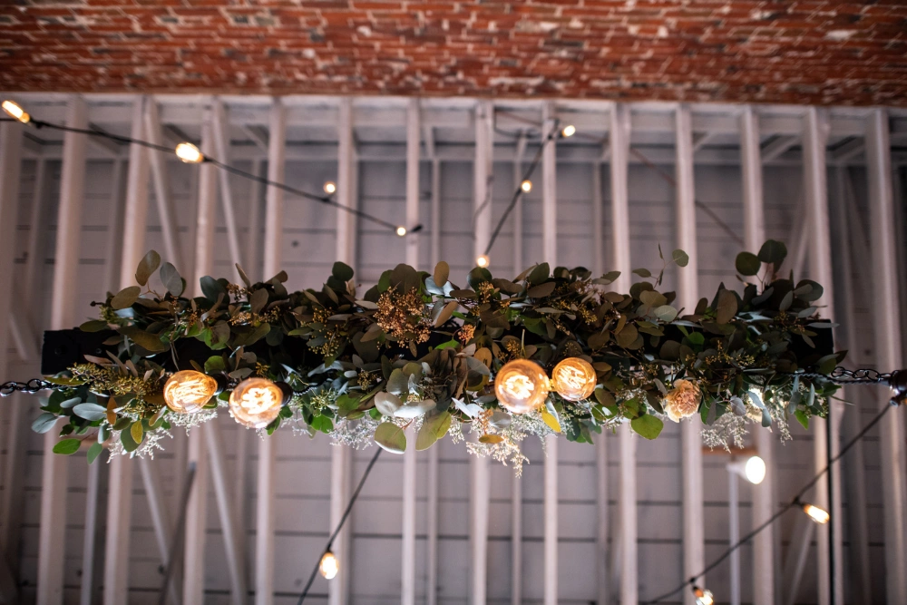 Sinclair on G Street wedding lighting with Edison bulbs and floral installation above bar for romantic reception atmosphere