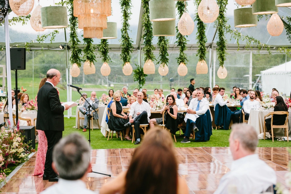 The Ranch at Laguna Beach wedding lighting with elegant hanging chandeliers and greenery inside outdoor tent reception