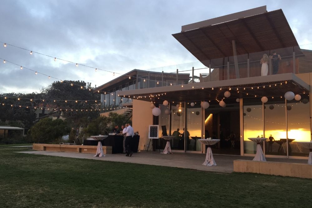 Scripps Seaside Forum wedding lighting at sunset featuring soft market lights and glowing interior spaces that enhance the venue’s coastal architecture